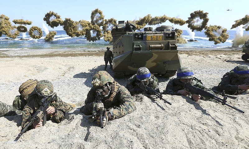 FILE - In this March 12, 2016, file photo, Marines of the U.S., left, and South Korea wearing blue headbands on their helmets, take positions after landing on a beach during the joint military combined amphibious exercise, called Ssangyong, part of the Key Resolve and Foal Eagle military exercises, in Pohang, South Korea. The Pentagon on Monday, June 18, 2018,  formally suspended a major military exercise planned for August with South Korea, a much-anticipated move stemming from President Donald Trump's nuclear summit with North Korean leader Kim Jong Un. (Kim Jun-bum/Yonhap via AP, File)