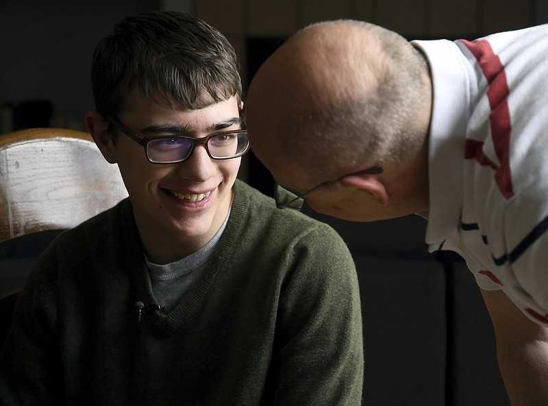 In this Monday, April 23, 2018, photo, Lukas Inman, 19, interacts with his father in Colorado Springs, Colo. Inman suffers from a rare and severe form of epilepsy called Lennox-Gastaut Syndrome. A British pharmaceutical company is getting closer to a decision on whether the U.S government will approve the first prescription drug derived from the marijuana plant, but parents, including Lukas,' who for years have used cannabis to treat severe forms of epilepsy in their children are feeling more cautious than celebratory. (AP Photo/Thomas Peipert)