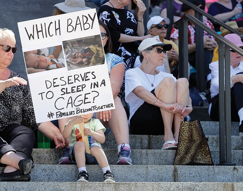 Christopher Baker, 3, holds a sign that reads "Which baby deserves to sleep in a cage?" on Monday as he attends a Poor People's Campaign rally with his mother, Katie Baker at the Capitol in Olympia, Wash. President Donald Trump defended his administration's border-protection policies Monday in the face of rising national outrage over the forced separation of migrant children from their parents. 