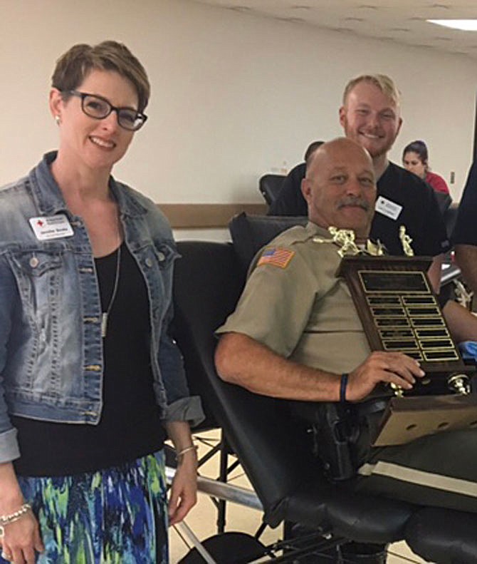 Callaway County Deputy Rick Hughes, participating with Fulton Police, displays the winning trophy while donating blood at the Fulton Police Department in 2017. The annual Battle of the Badges netted the Fulton Fraternal Order of the Police bragging rights for the third year in a row. When making a donation, the donor casts a vote for police, fire or EMS and the most votes wins. Pictured with Hughes are American Red Cross Account Manager Jennifer Books and Collection Supervisor Levi Lowther.