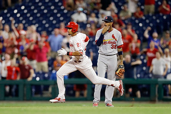 Aaron Altherr of the Phillies heads toward second past Cardinals first baseman Jose Martinez after Altherr hit a game-wining two-run double during the 10th inning of Monday night's game in Philadelphia.