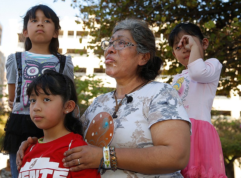 Lucia Ajas, middle, talks Monday about herself and her children, Regina Vargas, 7, left, Akemi Vargas, 8, second from left, and Trinidad Vargas, 5, right, being separated from the children's father during an immigration family separation protest in front of the Sandra Day O'Connor U.S. District Court building in Phoenix. 