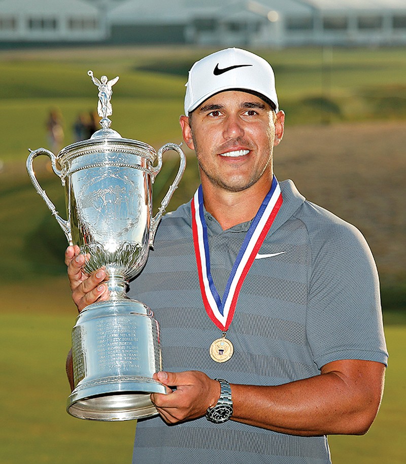 Brooks Koepka holds up the Golf Champion Trophy after winning the U.S. Open Golf Championship on Sunday in Southampton, N.Y