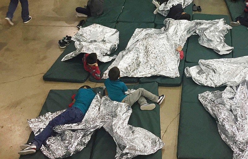 In this photo provided by U.S. Customs and Border Protection, children being detained at a facility in McAllen, Texas, are seen with large foil sheets intended to serve as blankets.