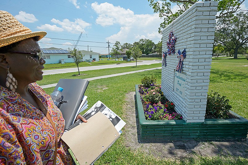 Carrie Mingo Douglas, a member of the Pontchartrain Park neighborhood association and chair of the association's historic district committee, walks around the historic sign of the housing development that she helps maintain on June 8 in New Orleans. Pontchartrain Park, the first subdivision to be built for affluent and middle-class African- American home owners in New Orleans, opened in June 1955. Neighbors are trying to have the neighborhood listed on the National Register of Historic Districts.  