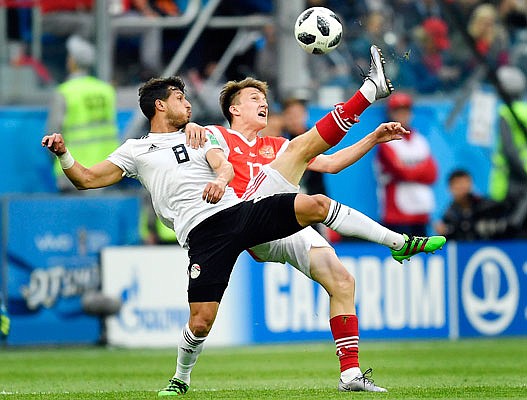 Egypt's Tarek Hamed (left) and Russia's Alexander Golovin compete for the ball Tuesday during the Group A match in St. Petersburg, Russia.
