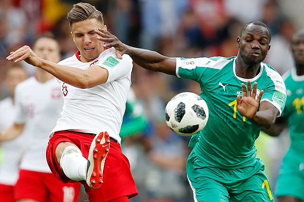 Poland's Jan Bednarek (left) clears the ball past Senegal's Moussa Konate during a Group H match Tuesday in Moscow.