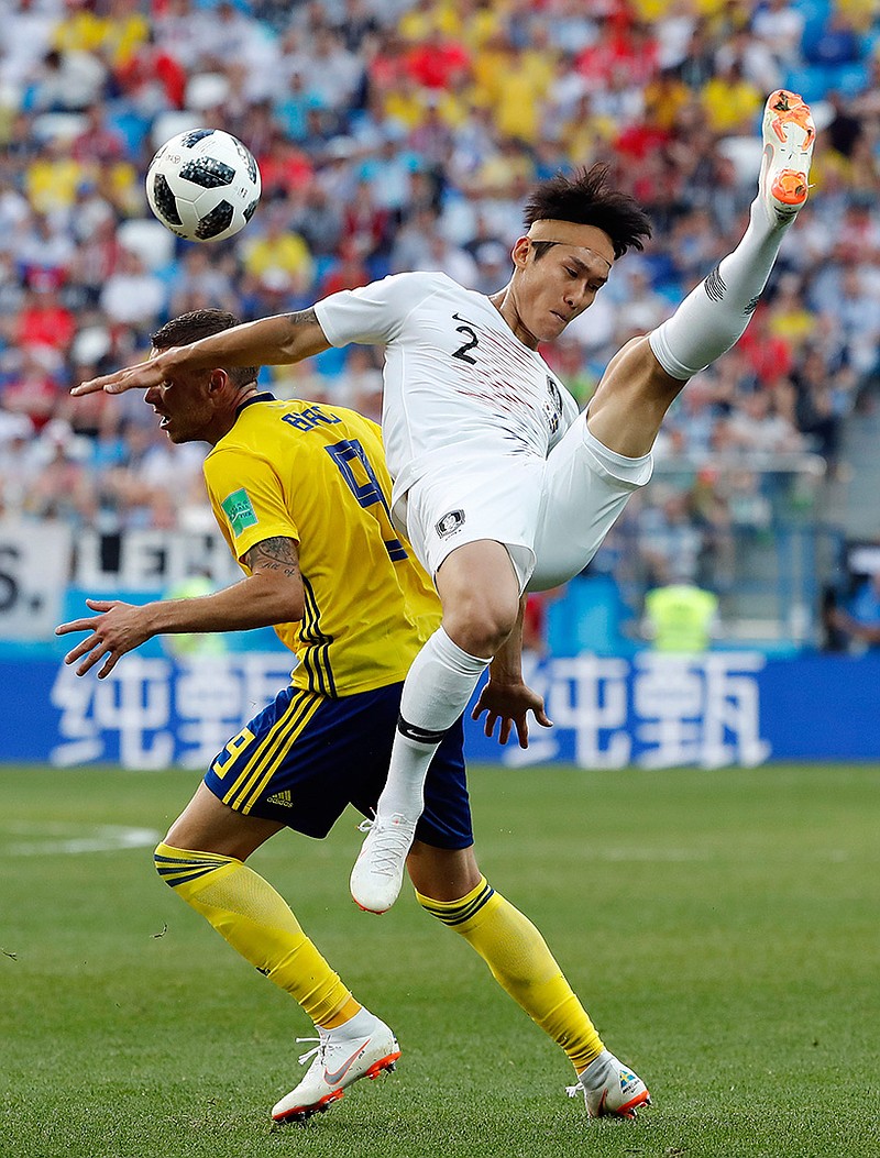 South Korea's Lee Yong is challenged by Sweden's Marcus Berg during the group F match between Sweden and South Korea on Monday during a World Cup match at the stadium in Nizhny Novgorod, Russia. See Page 2B for World Cup standings.