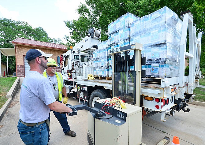 Shane Biessen of the Samaritan Center, left, and Roy Hall of Ameren Missouri unload donated air conditioning units from a truck Tuesday, June 19, 2018, at the Samaritan Center in Jefferson City.
