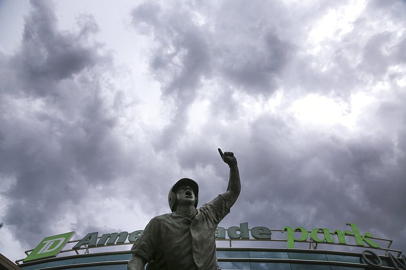 Heavy clouds cover the sky above TD Ameritrade Park and The Road to Omaha statue, during a weather delay in the NCAA College World Series baseball elimination game between Oregon State and Washington, in Omaha, Neb., Monday, June 18, 2018. 