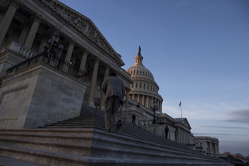 A congressman walks up the steps outside the U.S. Capitol Building at dusk on Jan. 20, 2018 in Washington, D.C. (Alex Edelman/CNP/Zuma Press/TNS)