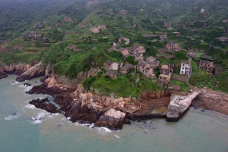 A photo taken by a drone May 19 shows the abandoned fishing village of Houtouwan on the remote island of Shengshan, about 55 miles off the coast of Shanghai. Only five of the 3,000 residents remain in what some call a "ghost village," where visitors walk along perilous footpaths that wind past structures worn down by roots, rain, vines and wind.