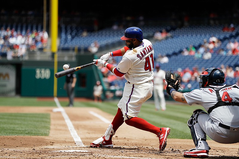 Philadelphia Phillies' Carlos Santana hits an RBI-sacrifice fly off St. Louis Cardinals starting pitcher Michael Wacha during the first inning of a baseball game Wednesday in Philadelphia.