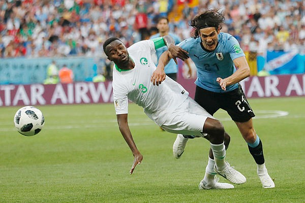 Uruguay's Edinson Cavani (right) and Saudi Arabia's Osama Hawsawi battle for the ball Wednesday during a Group A match in Rostov-on-Don, Russia.