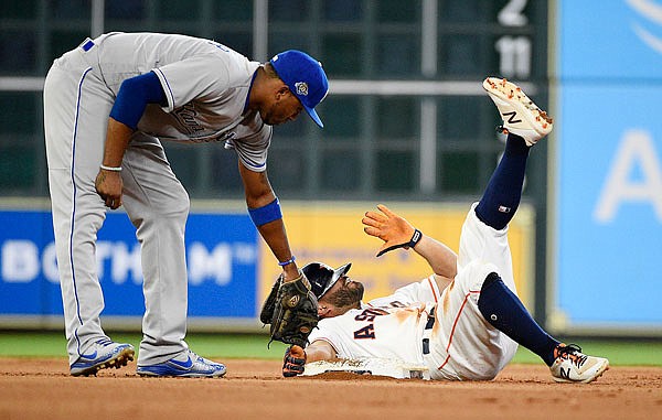 Jose Altuve of the Astros calls for time after sliding safely into second base for a double as Royals shortstop Alcides Escobar applies the tag during the fourth inning of Saturday night's game at Houston.