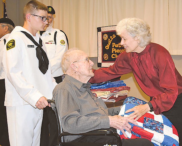 At right, Valerie Garrett presents a quilt to Bernard Heet during Sunday's Quilts of Valor ceremony at American Legion Post 5. Heet was a signal operator on a submarine chaser during World War II. Garrett is a member of Patriot Piecers, the local Quilts of Valor chapter.