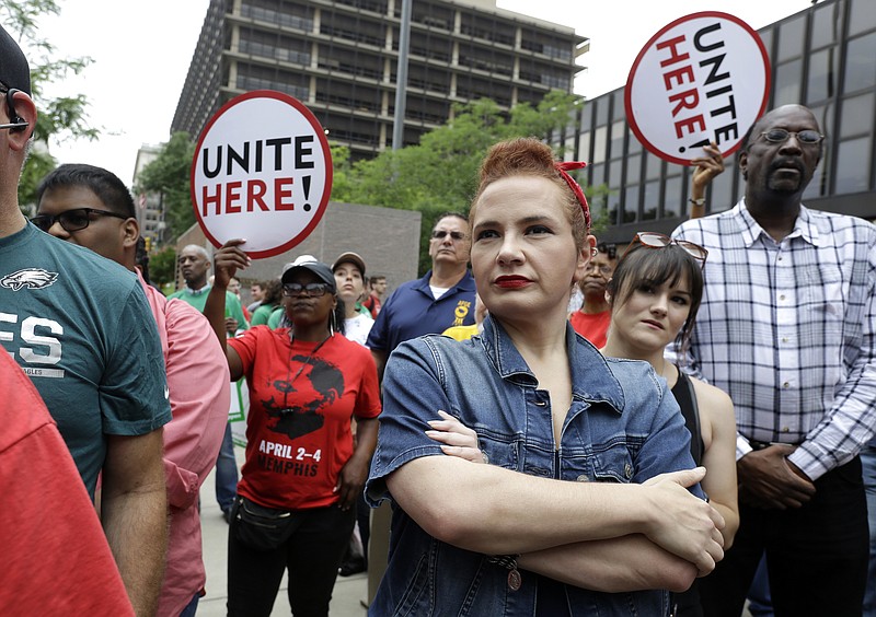 Amanda Hammock, center, a Delaware County, Pa. Democratic party activist, is dressed as Rosie the Riveter as she attends a protest by Philadelphia Council AFL-CIO Wednesday, June 27, 2018, in Philadelphia. The protesters denounced Wednesday's U.S. Supreme Court ruling that government workers can't be forced to contribute to labor unions that represent them in collective bargaining, dealing a serious financial blow to organized labor. (AP Photo/Jacqueline Larma)