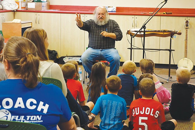 Mike Anderson, a musician and noisemaker from Illinois, teaches children how to clap with their fingers this week at the Callaway County Public Library in Fulton.