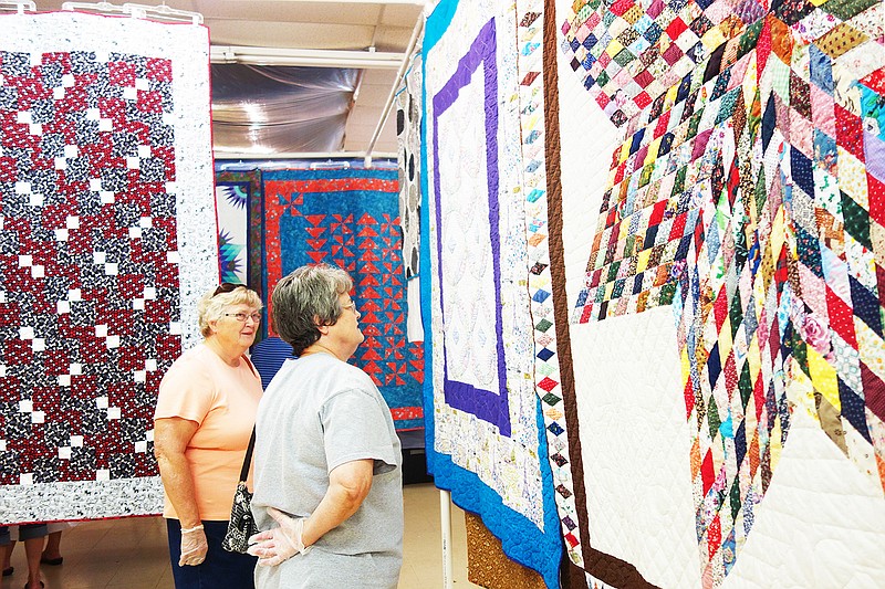 Carol, left, and Loretta Kerperin browse the quilts at the 2017 Rooster Creek Quilt Show in Holts Summit. Visitors at the quilt show could vote for their favorites in each of five categories, plus overall.