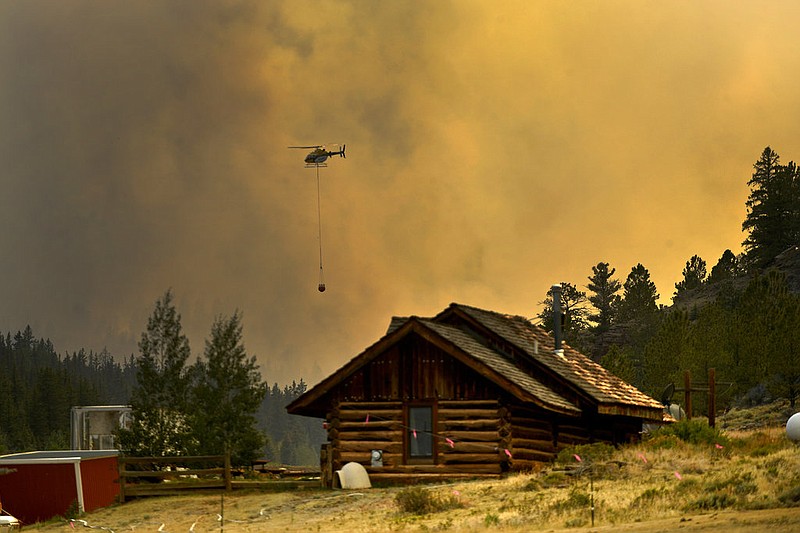 In this Monday, July 2, 2018 photo, a helicopter returns for water after making a water drop on a wildfire near Fairplay, Colo. The fire is burning about 20 miles south of Fairplay. 