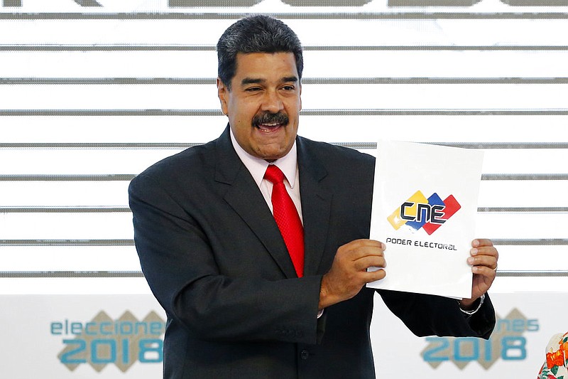  In this May 22, 2018, file photo, Venezuela's President Nicolas Maduro holds up the National Electoral Council certificate declaring him the winner of the presidential election, during a ceremony at CNE headquarters in Caracas, Venezuela. 