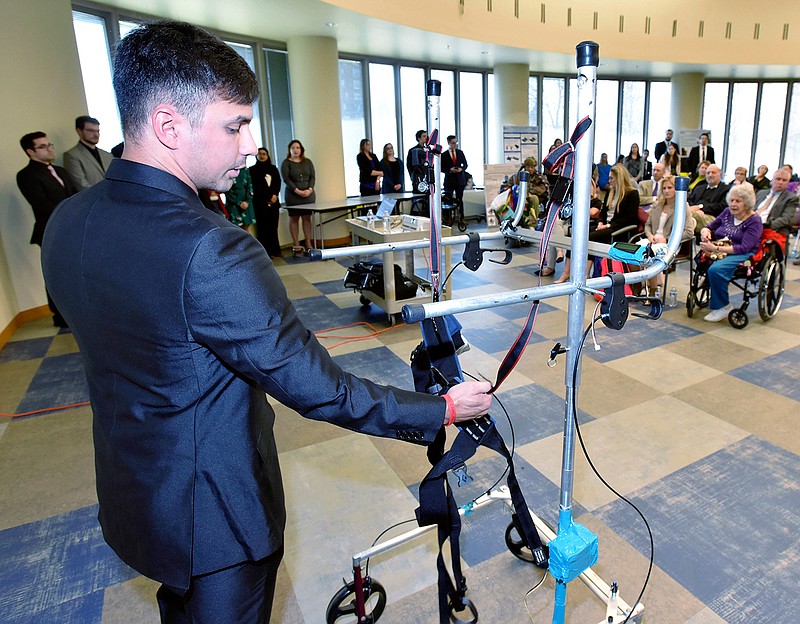 In this April 19, 2018, photo, University of Detroit Mercy mechanical engineering student Max Rogowski, 21, shows how a Gait Trainer helps people walk who have trouble supporting their own weight at the John D. Dingell Va Medical Center in Detroit. (Todd McInturf/Detroit News via AP)
