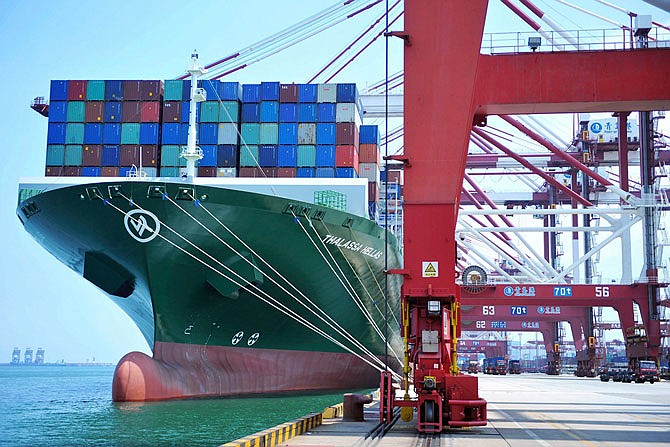 A ship hauls containers Friday at a port in Qingdao in eastern China's Shandong province. The United States hiked tariffs on Chinese imports Friday and Beijing said it immediately retaliated in a dispute between the world's two biggest economies that President Donald Trump says he is prepared to escalate.