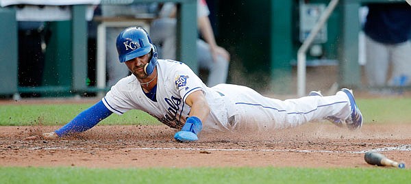 Whit Merrifield of the Royals slides home to score on a single by Mike Moustakas during the third inning of Saturday night's game against the Red Sox at Kauffman Stadium.
