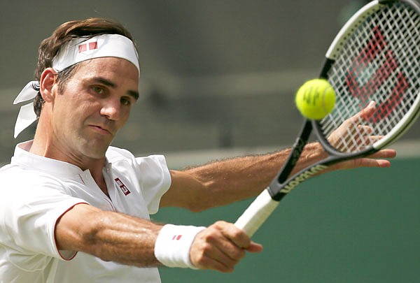 Roger Federer returns the ball to Adrian Mannarino during their men's singles match Monday at the Wimbledon Championships in London.