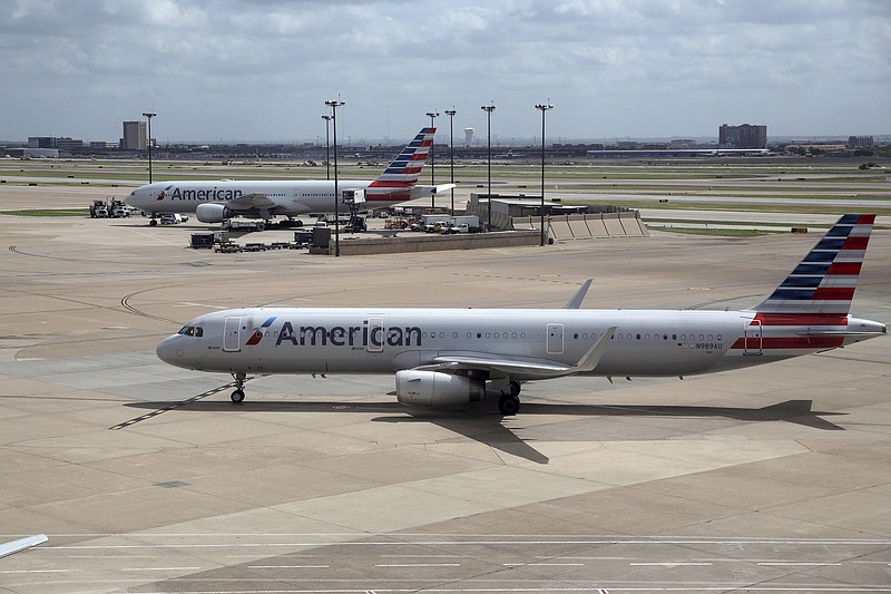 FILE - In this June 16, 2018 file photo, American Airlines aircrafts are seen at Dallas-Fort Worth International Airport in Grapevine, Texas. American Airlines says it will stop using plastic straws and drink stirs and replace them with biodegradable alternatives. American said Tuesday, July 10, 2018, that starting this month in its airport lounges it will serve drinks with straw and wood stir sticks and begin moving to what it called eco-friendly flatware. (AP Photo/Kiichiro Sato, File)
