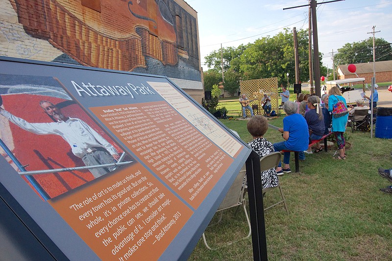 This large and colorful plaque renames Linden's Music City Texas corner mural space Attaway Park in honor of the late Brad Attaway, the mural's artist. Guests for the ceremonies Saturday are listening to music by Richard Bowden, John Early and Brad Attaway's brother Gregg Attaway.