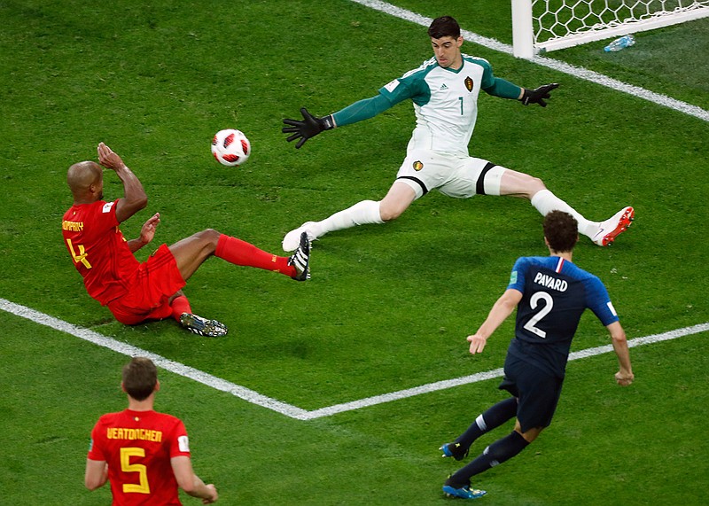 Belgium goalkeeper Thibaut Courtois, top right, makes a save in front of France's Benjamin Pavard, right, during the semifinal match between France and Belgium at the 2018 soccer World Cup in the St. Petersburg Stadium in St. Petersburg, Russia, Tuesday, July 10, 2018. (AP Photo/Pavel Golovkin)
