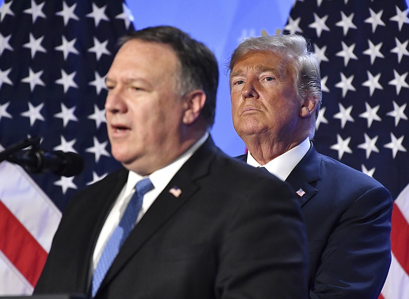 U.S. President Donald Trump, right, listens to U.S. Secretary of State Mike Pompeo during press conference after a summit of heads of state and government at NATO headquarters in Brussels, Belgium, Thursday, July 12, 2018. NATO leaders gather in Brussels for a two-day summit. (AP Photo/Geert Vanden Wijngaert)