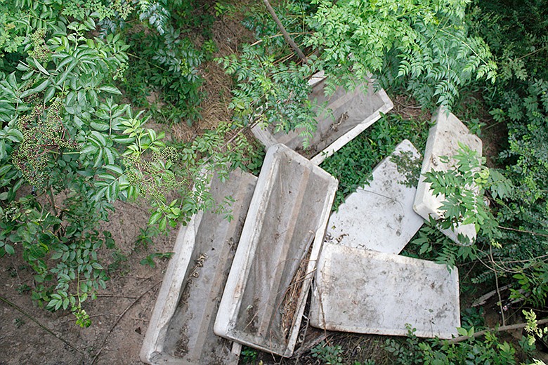 Mattresses lie at the north end of a bridge crossing Days Creek on South State Line Avenue. Trash lines the edges of the bridge where people have illegally dumped household items instead of disposing of them properly.