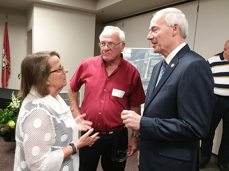 Former Arkansas Rep. Prissy Hickerson, left, and her husband, Randy, middle, speak to Arkansas Gov. Asa Hutchinson on Friday, July 13, 2018, in Ashdown, Ark. The officials attended a reception for Vickie Williamson, the new intermodal and developmental director for Little River County.