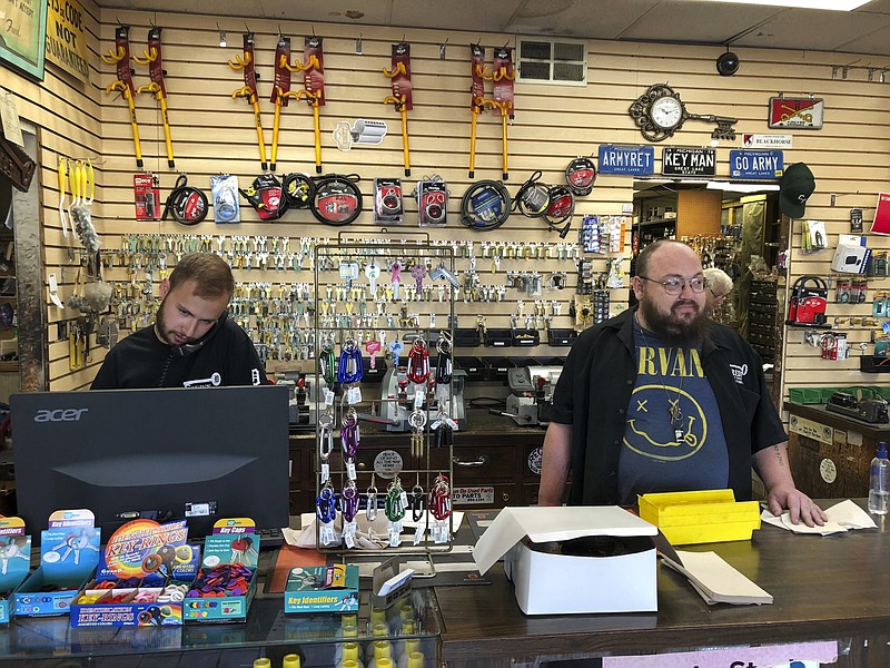 In this July 11, 2018 photo, James Murphy, left, and Bryan Knoche work the counter at Fred's Key Shop in Midtown Detroit. Five years after Detroit filed for the largest municipal bankruptcy in U.S. history, Knoche says the small, family-owned locksmith business is "busier than ever" because more people are moving into the area. (AP Photo/Corey Williams)
