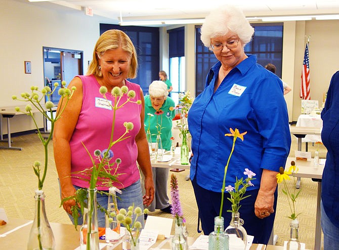 Marcia Guerrant, left, and Darla Douglas look over entries at the Fulton Garden Club's annual Flower Show. The Friday competition drew fewer entries than usual due to a hot, dry summer.