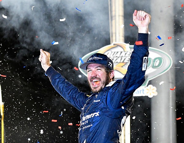 Martin Truex Jr. raises his arms in celebration following his victory Saturday night in the NASCAR Cup Series race at Kentucky Speedway in Sparta, Ky.