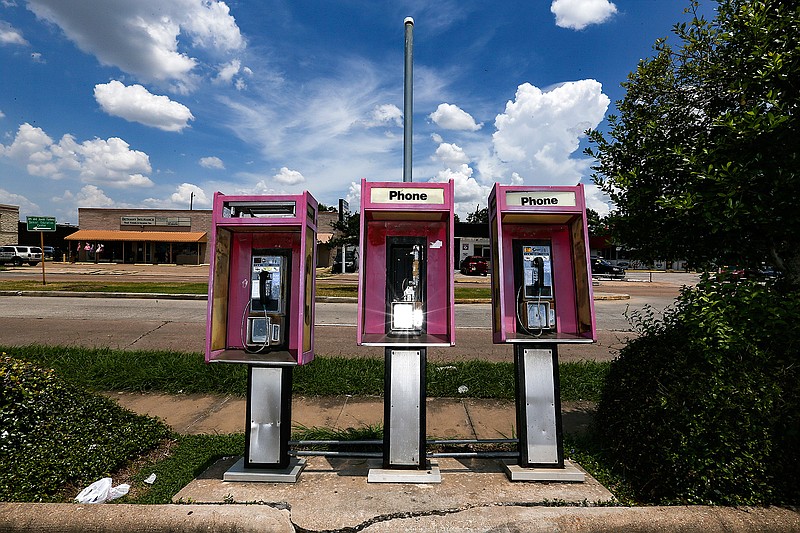 This Friday, July 13, 2018 photo shows pay phones in front of a Gulf gas station on Hillcroft Street in Houston. A Houston-area man must serve 18 months in federal prison and repay $2.4 million for what prosecutors call a pay phone scam since 2005. David Grudzinski of Friendswood was sentenced Friday in Houston. Investigators say Grudzinski owned about 450 pay phones in the Houston area. Grudzinski acknowledged a scheme to unlawfully obtain payments from the owners of toll-free numbers for calls to his pay phones. (Elizabeth Conley/Houston Chronicle via AP)