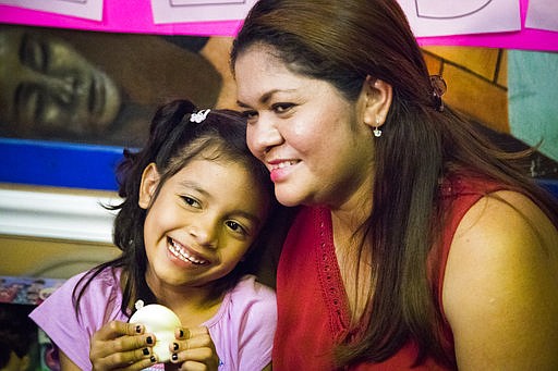 Allison, 6, and her mother Cindy Madrid share a moment during a news conference, Friday, July 13, 2018, in Houston. The press conference, the mother and daughter spoke about the month and one day they were separated under the President Donald Trump administration immigration policy that has separated families attempting to claim asylum in the United States. (Marie D. De Jes's/Houston Chronicle via AP)