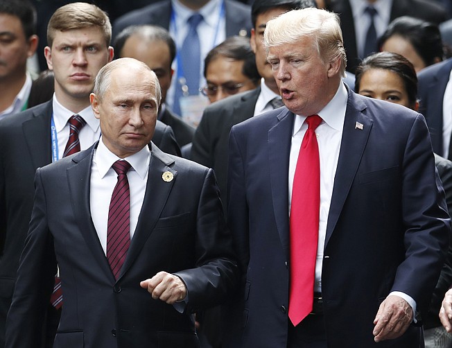 In this Nov. 11, 2017 file photo, U.S. President Donald Trump and Russia's President Vladimir Putin talk during the family photo session at the APEC Summit in Danang, Vietnam. The outcome of the first summit between the unpredictable first-term American president and Russia's steely-eyed longtime leader is anybody's guess. With no set agenda, the summit could veer between spectacle and substance. As Donald Trump and Vladimir Putin head into their meeting, Monday, July 16, 2018 in Helsinki, here's a look at what each president may be hoping to achieve:  (Jorge Silva/Pool Photo via AP, File)