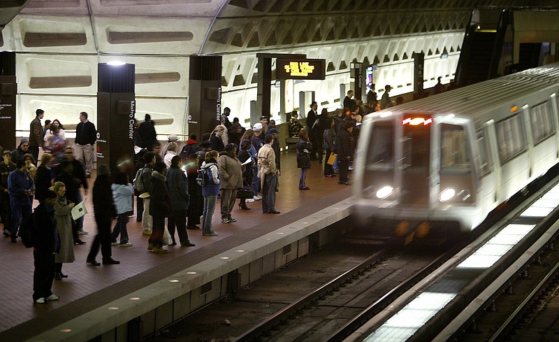 FILE - In a Monday, April 5, 2004 file photo, riders wait to board an arriving train at the D.C. Metro Center, in Washington. Metro’s largest union has overwhelmingly authorized a potential transit system strike, just as thousands of tourists arrive in the nation’s capital for the July 17, 2018 Major League Baseball All-Star Game. Union leaders said they would wait on Monday’s expected response from Metro’s management after Sunday’s vote authorizing a strike.  (AP Photo/Lawrence Jackson, File)