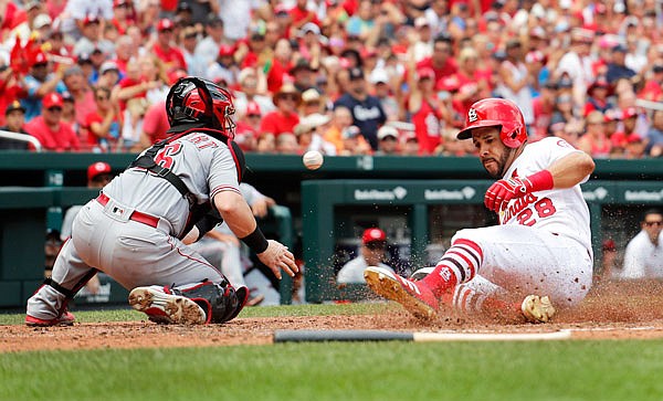 Tommy Pham of the Cardinals scores past Reds catcher Tucker Barnhart during the fourth inning of Sunday afternoon's game in St. Louis.