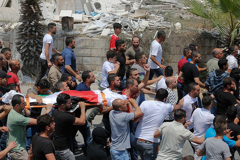  Palestinians carry the body of Rami Sabarna during his funeral on Saturday in the West Bank village of Beit Ummar. Sabarna was shot and killed by Israeli troops in the Old City of Hebron after he reportedly attempted to ram with a skid loader Israeli forces guarding the entrance to the Ibrahimi mosque, also known as the Cave of the Patriachs.