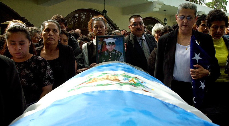 Relatives of Guatemalan-born Marine Lance Cpl. Jose Antonio Gutierrez, one of the first combat casualties of the Iraq War, gather around his casket April 9, 2003, at his funeral at Los Cipreses cemetery in Guatemala City. Gutierrez, who entered to U.S. illegally as an orphan teen, was killed in battle around the port city of Umm Qasr. Hundreds attended his memorial service outside of Los Angeles. He was granted American citizenship posthumously. (AP Photo/Moises Castillo, File)