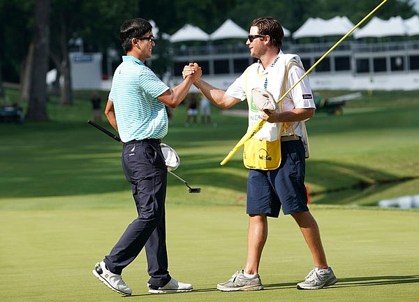Michael Kim (left) celebrates with his caddie Andrew Gunderson on Sunday after winning the John Deere Classic at TPC Deere Run in Silvis, Ill.