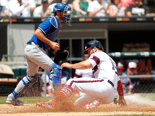 Daniel Palka of the White Sox slides safely into home plate to score a run past Royals catcher Drew Butera during the third inning of Sunday's game in Chicago.