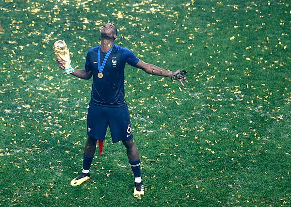 France's Paul Pogba celebrates with the World Cup trophy after winning the final match Sunday against Croatia at the Luzhniki Stadium in Moscow.