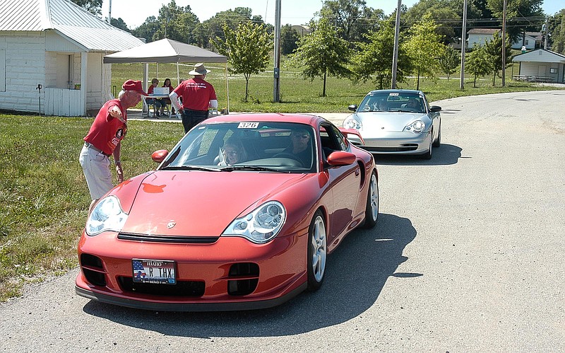 <p>Democrat photo / David A. Wilson</p><p>A pair of Porches go through the checkpoint in the Time, Speed and Distance Rally, at the Moniteau County Fairgrounds. The 2002 red Porsche belongs to Bill and Laura Stover, Idaho. The second car, a 2003 silver Porsche, is owned by Tom and Cindy Briest, Tarpon Springs, Florida.</p>