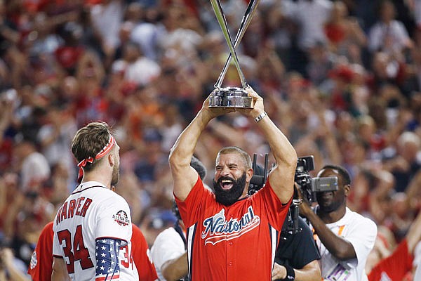 Ron Harper holds the Home Run Derby trophy won by his son, Bryce, Monday night in Washington.